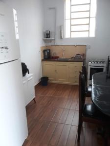 乌贝拉巴Casa Patrimônio Histórico - Centro de Uberaba的厨房铺有木地板,配有水槽和冰箱。