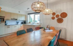 玛库姆Stunning Home In Makkum With Wifi的厨房以及带木桌和椅子的用餐室。