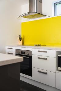 但尼丁Urban Sanctuary on Union的厨房设有黄色墙壁和炉灶。