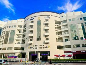 迪拜AlRaef Luxury Apartments的一座白色的建筑,与Akhtar酒店同在