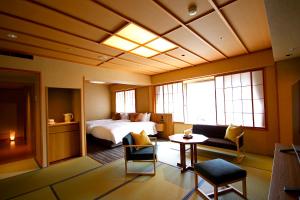 高山Hida Takayama Onsen Hida Hotel Plaza的酒店客房带一张床、一张桌子和椅子