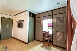 CavintiCaliraya Ecoville Recreation and Farm Resort的一间设有门、椅子和窗户的房间