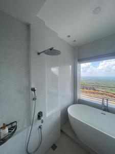 BlimbingManca Kemetug的白色的浴室设有浴缸和窗户。