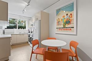 墨尔本Urban Retro - Experience Vibrant Courtyard Charm的厨房以及带桌椅的用餐室。