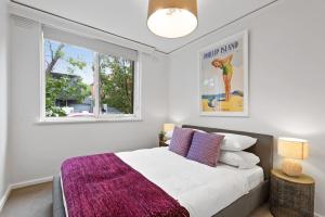 墨尔本Urban Retro - Experience Vibrant Courtyard Charm的一间卧室配有一张带紫色毯子的床