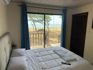 雅科Pura Vida Macaw Paradise的一间卧室配有一张床,享有海景
