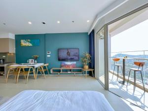 头顿CĂN HỘ 5 SAO THE SÓNG VŨNG TÀU Mr VƯƠNG的一间卧室设有蓝色的墙壁和桌椅