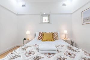伊斯特伍德Homely 4 Bdrms House in Eastwood Sleeps 11的白色卧室配有一张带两盏灯的大床