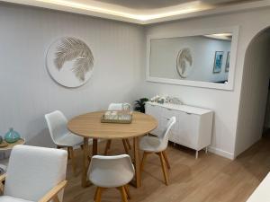 黄金海岸鹈鹕湾公寓酒店的一间带桌子和白色椅子的用餐室
