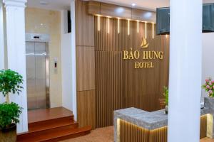 清化Bảo Hưng Hotel的墙上挂着宝岛生活酒店标志的大堂