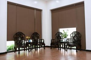 清化Bảo Hưng Hotel的用餐室设有椅子、桌子和窗户
