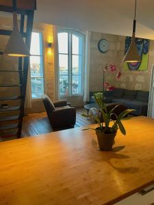 波尔多Les Capucins的客厅配有木桌和植物