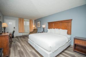 汤森德Tremont Lodge & Resort的卧室配有一张白色大床和一张书桌