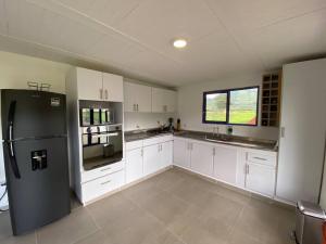 佩雷拉Life is Beautiful! Cottage in the Nature的厨房配有白色橱柜和黑色冰箱。