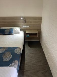 扬巴扬巴阿斯顿汽车旅馆的酒店客房带两张床和一面墙