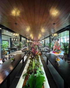 TanauanThe Vineyard at Tanauan的餐厅设有木桌和椅子,种有植物