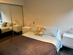 奥克兰Lovely 2 bedrm apartment in Auckland's viaduct的一间卧室配有一张带枕头的床