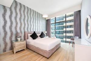 迪拜FAM Living - Mada Residences Downtown Dubai的卧室设有白色的床和大窗户