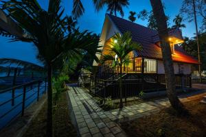 ElūrLiara Fish Net Villa的棕榈树的海滩上度假屋