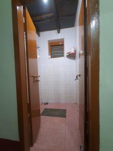 乌杜皮Hallimane Homestay的带淋浴的浴室,铺有瓷砖地板。