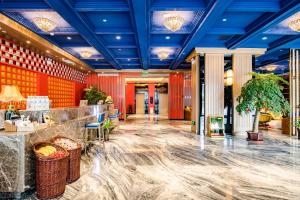 拉萨美豪酒店拉萨店的大堂设有红色的墙壁和蓝色的天花板。