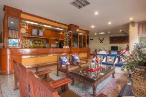 南邦Khelang Nakorn Hotel的客厅设有带桌椅的酒吧