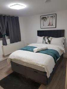 吉林汉姆Holiday Let - Entire modern home in Medway的一间卧室配有一张大床和黑色床头板