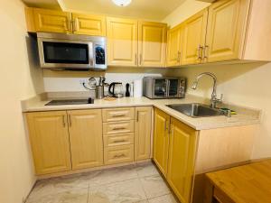布兰普顿Scotchmere Serenity: Modern 1-Bedroom Brampton Haven的厨房配有木制橱柜、水槽和微波炉