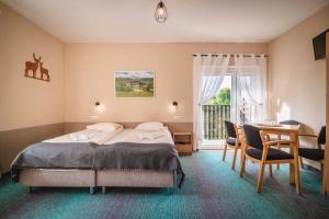 杜什尼基-兹德鲁伊Granada Pensjonat & SPA的卧室配有一张床和一张桌子及椅子