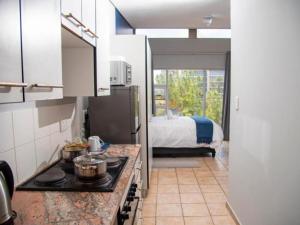 比勒陀利亚Leas Furnished Apartments - Capital Hill的一间带炉灶的厨房和一张位于客房内的床。