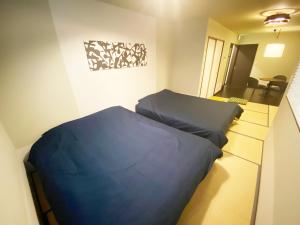 京都KAMON INN AIHUKA的一间位于客房内的蓝色床卧室