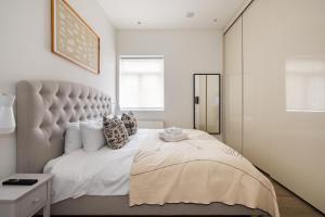 伦敦Luxury and Cool 2 bedroom in Notting Hill的一间卧室配有一张大床和大床头板