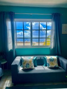 阿德耶Sunset View Balcon del Atlantico fase IV in Torviscas的窗户前带枕头的蓝色沙发