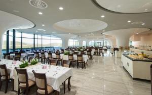 内乌姆Grand Hotel Neum Wellness & Spa的用餐室设有桌椅和窗户。