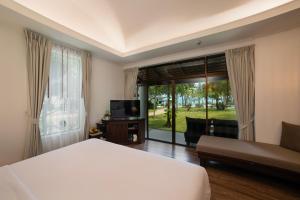 波普托Celes Samui的酒店客房设有一张床和一个大窗户