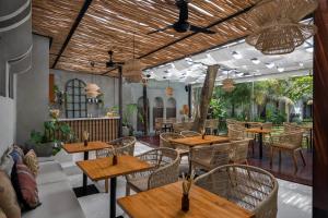 乌布Dinara Ubud的户外餐厅设有木桌和椅子