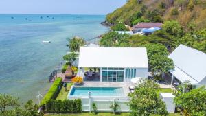 Ban Samae SanOne Villa Samaesarn的享有带游泳池和大海的房屋的空中景致