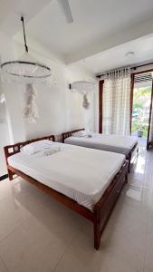 哈巴拉杜瓦Dream Villa with Pool的一间卧室配有两张床和吊灯。
