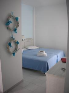 卡普萨利奥埃尔索尔酒店的卧室配有蓝色床,墙上装饰有蓝色