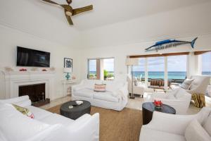 罗克桑德Palm Hill House home的客厅配有白色家具,享有海景。