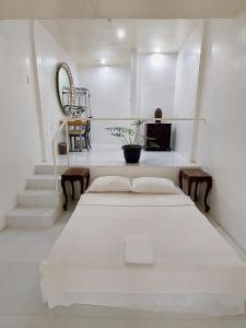 MolavePaglinawan Organic Eco Farm的一间白色的卧室,配有床和楼梯