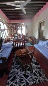 拉穆Yaye House的一间设有两张床和一张桌子及椅子的房间