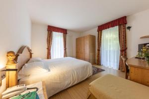 圣马蒂诺-迪卡斯特罗扎Hotel Plank的卧室配有一张床、一张书桌和窗户。