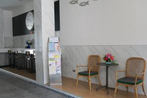 清莱The Mira Hotel Chiang Rai的一间钟表房里配有两把椅子和一张桌子