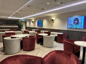 爱丁堡Tynecastle Park Hotel的餐厅设有桌椅和平面电视。