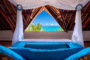 迪亚尼海滩爱水者海滩度假村的一张带海景窗户的床