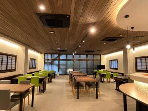 宫岛樱谷酒店的餐厅设有木制天花板、桌子和绿色椅子