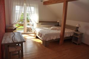 SukturiViesu nams Bezdubeņi的一间卧室设有一张床和一个大窗户