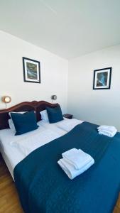 马里博Søpark Apartments的一张蓝色和白色的床,上面有毛巾