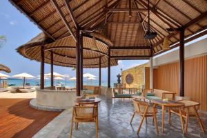 蓝梦岛蓝梦海滩俱乐部和度假酒店的户外用餐区配有桌椅和遮阳伞。